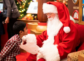 Image: A little boy shares his Christmas list with Santa