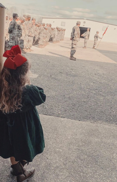 Image: A little girl watchers her dad in military service
