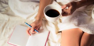 Image: A woman writing in a gratitude journal with a cup of coffee