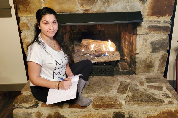 sitting by the fire place with a journal Vision Board: A Simple Beginners Guide to Vision Boards and Goal Setting Minerva Roca Contributor Miami Mom Collective