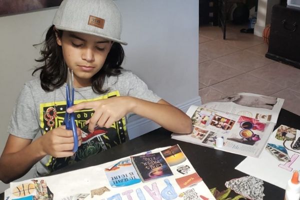 A boy cutting pictures from magazines for his vision board (Vision Boarding: How to Create a Vision Boards for Children Illiett Ojeda Contributor Miami Mom Collective)