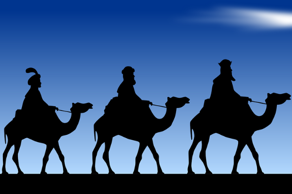 Image: Three camels and riders silhouetted against the sky