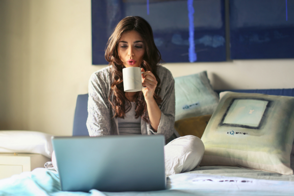 A woman sitting in front of a laptop with a cup of coffee (Getting and Staying Organized: 3 Helpful Tips Krystal Giraldo Contributor Miami Mom Collective)
