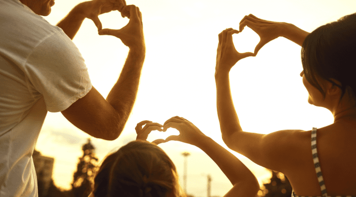 A family making hearts with their hands (Love Where You Live: Why I Love Living in Hialeah Lorena Lougedo Contributor Miami Mom Collective)