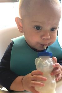 Andrea's daughter using a straw bottle (Overcoming My Solid Feeding Fears: A Journey of an Anxious Mom Andrea Wood & Cindy Herde Contributors Miami Mom Collective)