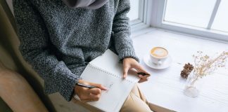 Mujer sentada y escribiendo en un diario (Me convertí en mamá y quise replantear mi profesión Karla Camacho Contributor Miami Mom Collective)