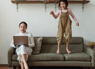 A mom working from home while her daughter plays (5 Steps to Supporting Your "Single Mom" Friends Kristen Llorca Contributor Miami Mom Collective)