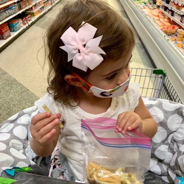 A little girl enjoying a snack while grocery shopping (Alexa Gonzalez Contributor Miami Mom Collective)