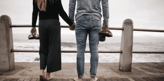 Image: A couple standing side by side on a pier