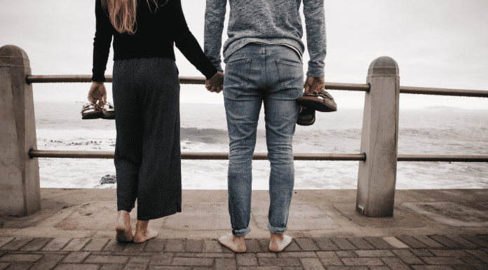 Image: A couple standing side by side on a pier