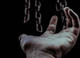 Chains hanging over an open hand (Liberty and Justice for All: Why Should I Care About Juneteenth? Becky Gonzalez Contributor Miami Mom Collective)