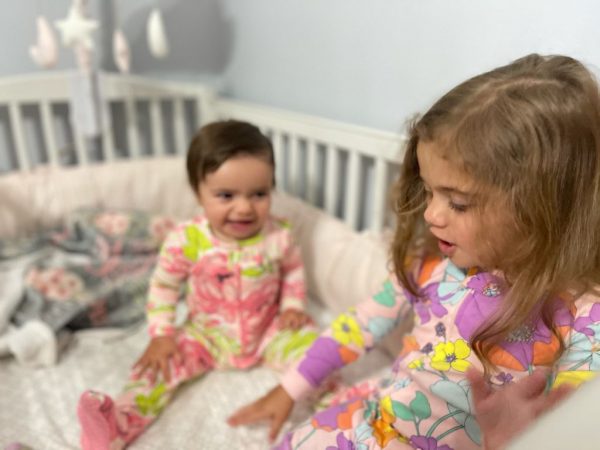 Image: Alexa's daughters sitting in the baby's crib (A New Roommate and a New Bed (All at Once!): Our Experience Alexa Gonzalez Contributor Miami Mom Collective)