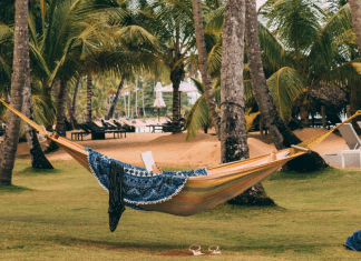 A woman in a hammock reading a book (Summer Reading List for Moms Krystal Giraldo Contributor Miami Mom Collective)