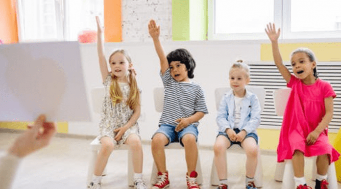A group of children raising their hands (Your Child Votes YES! Getting Involved at Your Child's School Matters! Holly Farver Contributor Miami Mom Collective)