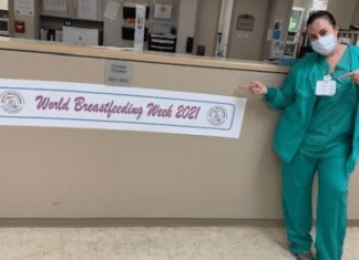 A nurse posing next to a banner for World Breastfeeding Week (World Breastfeeding Week: Raising Global Awareness Alexa Gonzalez Contributor Miami Mom Collective)