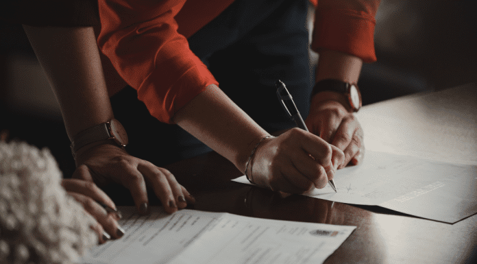 A couple signing documents (Designation of Health Care Surrogate for A Minor: What You Should Know Kristina Hernandez Tilson Contributor Miami Mom Collective)