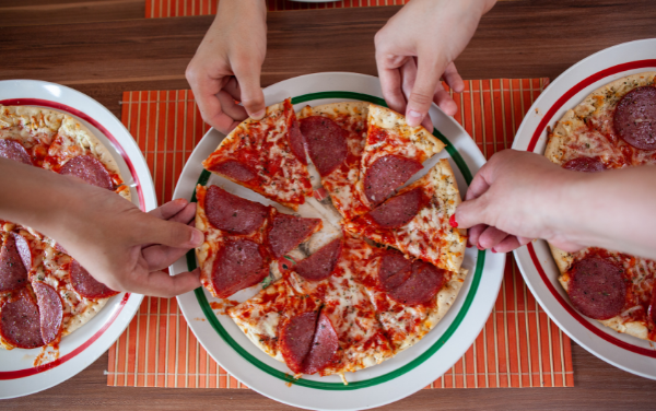 Image: A group of people sharing a pizza (Pizza Night: 10 Homemade Pizza Ideas for a Fun Family Friday Night Lorena Lougedo Contributor Miami Mom Collective)