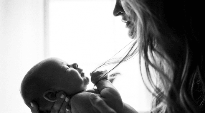 A mother holding her infant (To Parent in a Broken World Kristin Parke Contributor Miami Mom Collective)