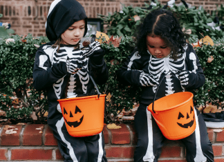 Image: Two girls in skeleton costumes sitting with their Halloween buckets (Allergy-Friendly Halloween: Tricks and Treats Monica Moreno Contributor Miami Mom Collective)