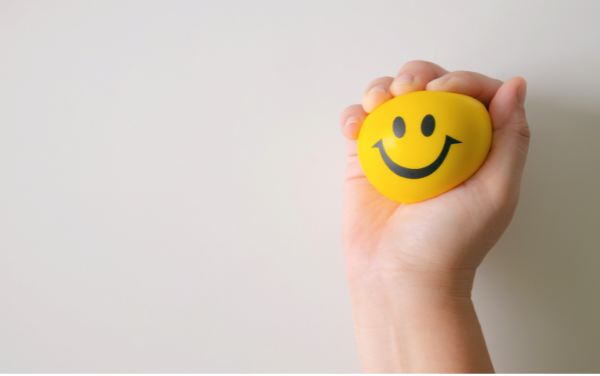 Image: A hand squeezing a stress ball (Minimize Stress: 18 Helpful Tips Lorena Lougedo Contributor Miami Mom Collective)