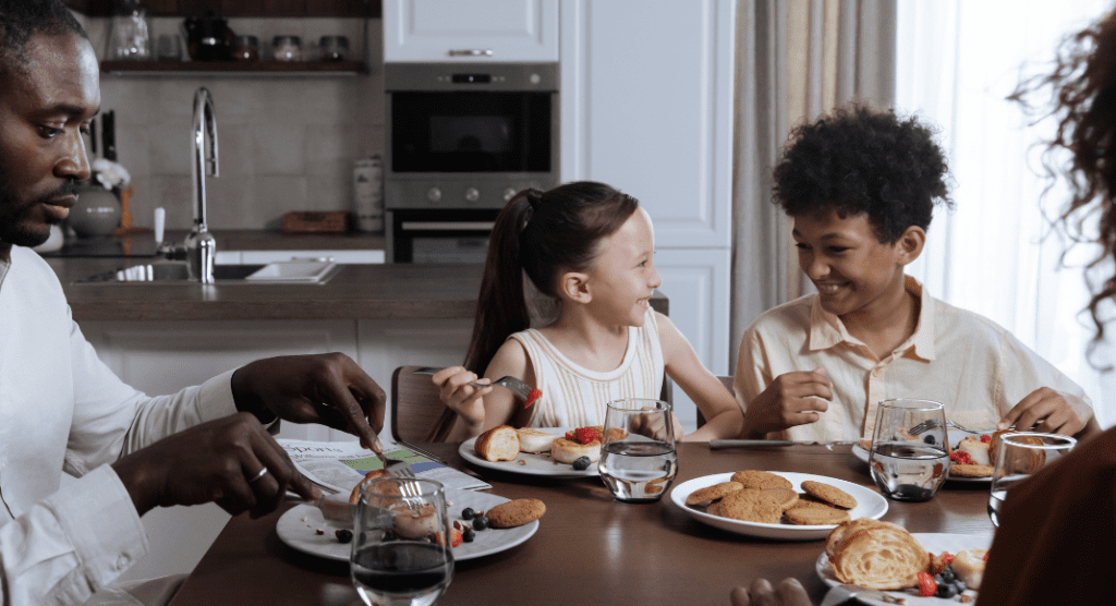 Image: A family sitting around the dinner table (How to Deal With a Picky Eater Dina Garcia Contributor Miami Mom Collective)