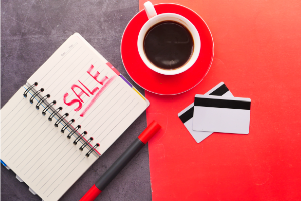 Image: An open notebook, a pen, a cup of coffee, and two credit cards on a table (Black Friday Deals: 5 Ways to Make the Most of Them Ana-Sofia DuLaney Contributor Miami Mom Collective)