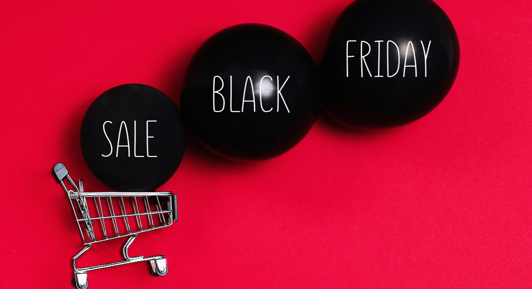 Image: A shopping cart and black balloons that read "Sale Black Friday" (Black Friday Deals: 5 Ways to Make the Most of Them Ana-Sofia DuLaney Contributor Miami Mom Collective)