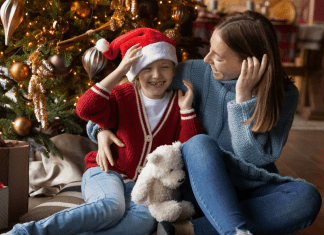 Image: A mother and daughter sitting in front of their Christmas tree (Healthy Holidays: A Survival Guide | Part 1 Dina Garcia Contributor Miami Mom Collective)