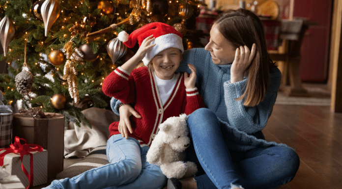 Image: A mother and daughter sitting in front of their Christmas tree (Healthy Holidays: A Survival Guide | Part 1 Dina Garcia Contributor Miami Mom Collective)