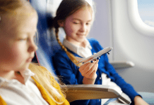 Image: Two girls sitting together on an airplane (Holiday Travel: The Ultimate Prep List for Smooth Family Travel Vanessa Santamaria Contributor Miami Mom Collective)