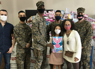 Image: Adita and her daughter with several US Marines standing in front of Toys for Tots collection boxes (Toys for Tots: Making a Difference for America's Children Adita Lang Contributor Miami Mom Collective)