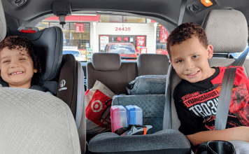 Image: Two kids in their car seats ready for a family road trip (Holiday Travel: 3 Ways to Balance Structure & Spontaneity | Dr. Bob Lynda Lantz Editor Miami Mom Collective)