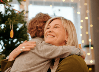 Image: A grandmother hugging her grandson at Christmas (Holiday Travel and Gatherings: Protecting Your Family From COVID & Flu Lynda Lantz Editor Miami Mom Collective)