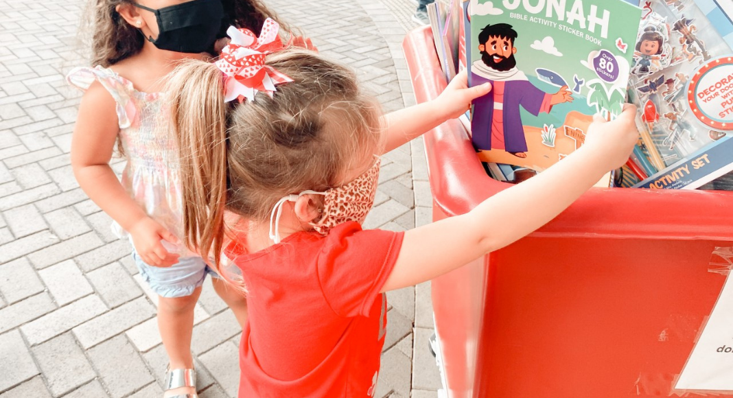 Image: A child donating a toy (Christmas: An Awesome Opportunity to Volunteer as a Family Holly Farver Contributor Miami Mom Collective)
