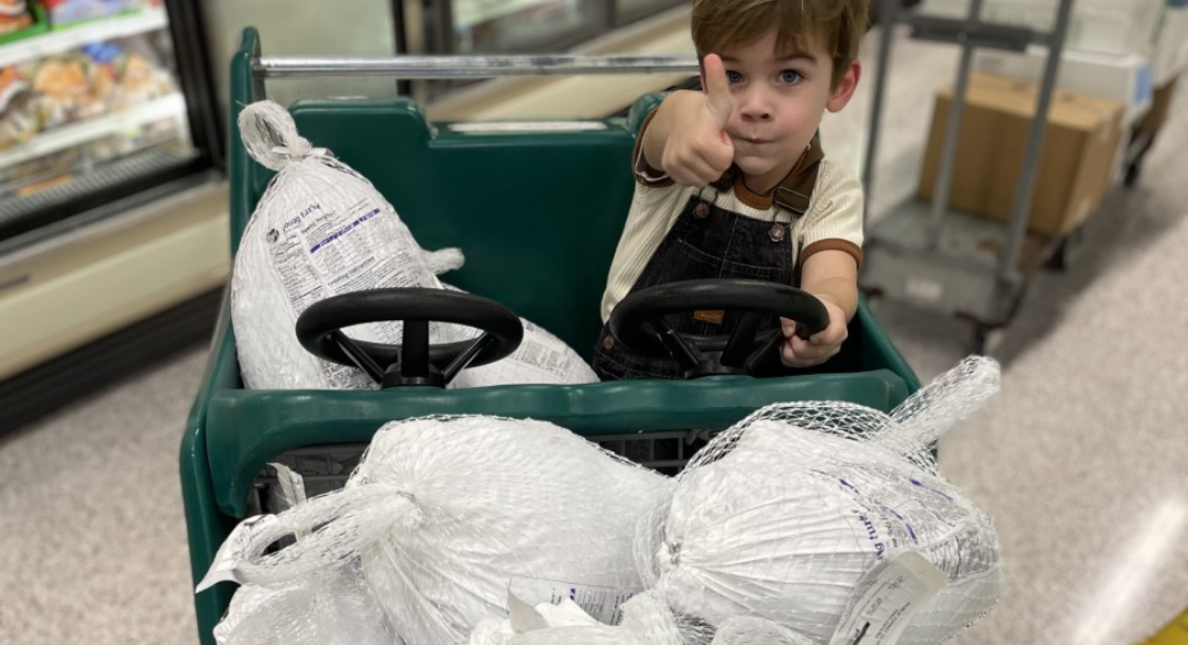 Image: A little boy in a shopping cart with several frozen turkeys (Holly Farver Contributor Miami Mom Collective)