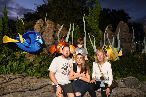 Image: Sandra and her family posing in front of the characters from Finding Nemo (Disney For The Holidays, and Some Magical Tips Sandra Jacquemin Contributor Miami Mom Collective)