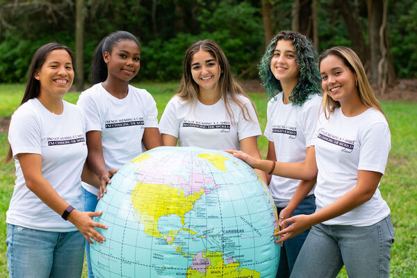 Image: A group of young women holding a large inflatable globe