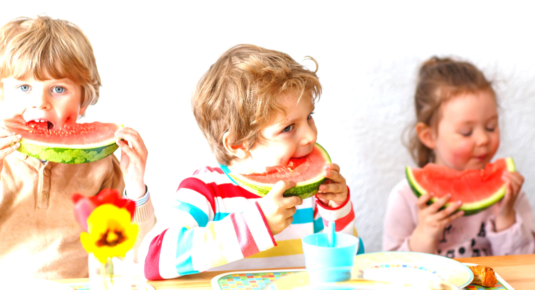 Three children enjoying slices of watermelon as a healthy snack
