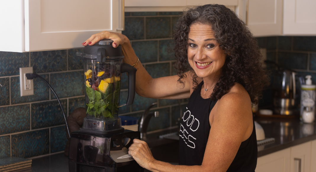 Image: Adita stands in her kitchen with her blender (Mama, It's Time to Prioritize YOU! Adita Lang Contributor Miami Mom Collective)