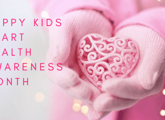 Image: A child holds a decorative ceramic heart in their hands with text that reads, "Happy Kids Heart Health Awareness Month" (Heart Health Month for Kids: Little Hearts, Big Bites Monica Moreno Contributor Miami Mom Collective)