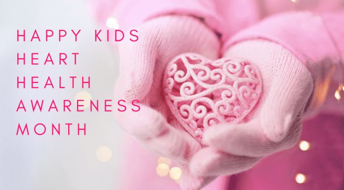Image: A child holds a decorative ceramic heart in their hands with text that reads, "Happy Kids Heart Health Awareness Month" (Heart Health Month for Kids: Little Hearts, Big Bites Monica Moreno Contributor Miami Mom Collective)