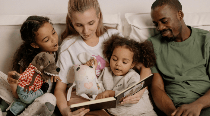 Image: A multi-racial family sitting a reading a book together