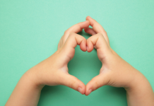 Image: A child makes a heart with their hands