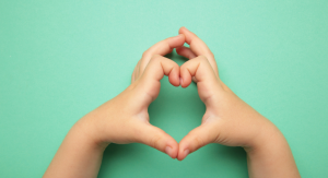 Image: A child makes a heart with their hands