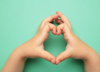 Image: A child makes a heart with their hands