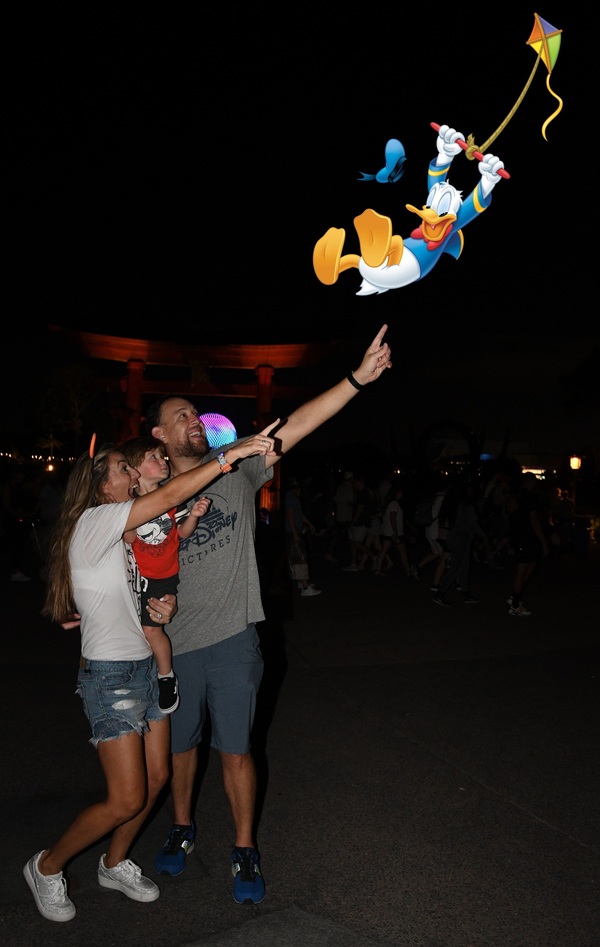 Sandra and her family pointing to a virtual image of Donald Duck