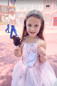 Child enjoying a Mickey Bar Ice Cream at Magic Kingdom. 