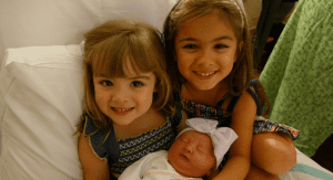 Grettel's oldest daughters holding their newborn sister