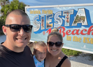 Holly's son with his family in front of a Siesta Beach sign