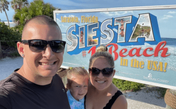 Holly's son with his family in front of a Siesta Beach sign